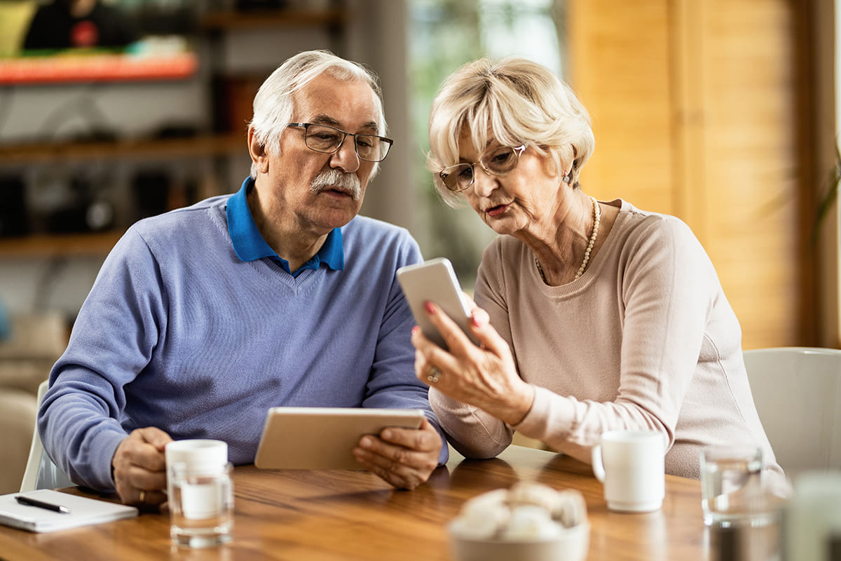 Couple seniors sur tablette et smartphone